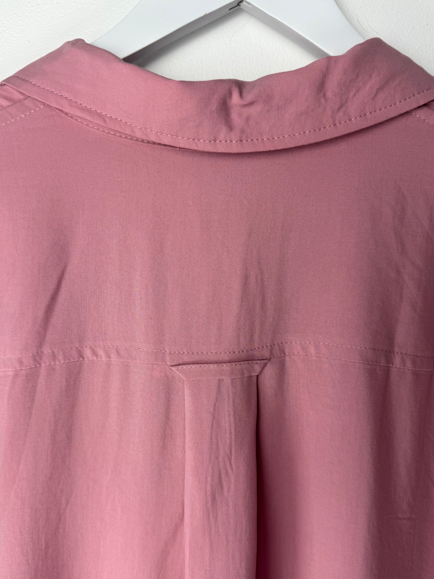 Close-up of a pink garment collar from back on a white background