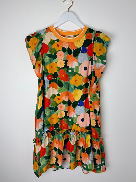 Colorful floral dress on a white hanger against a white background
