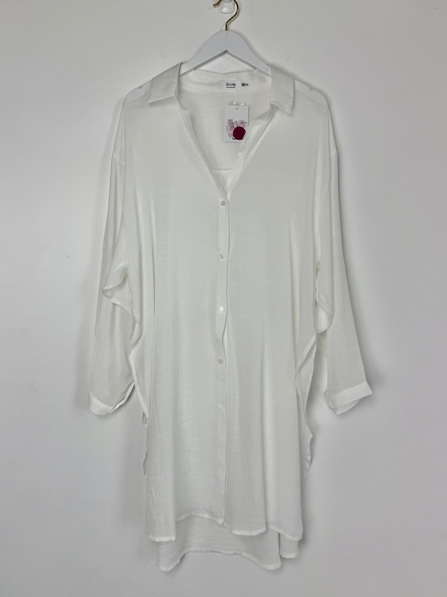 White shirt on a hanger against a white background