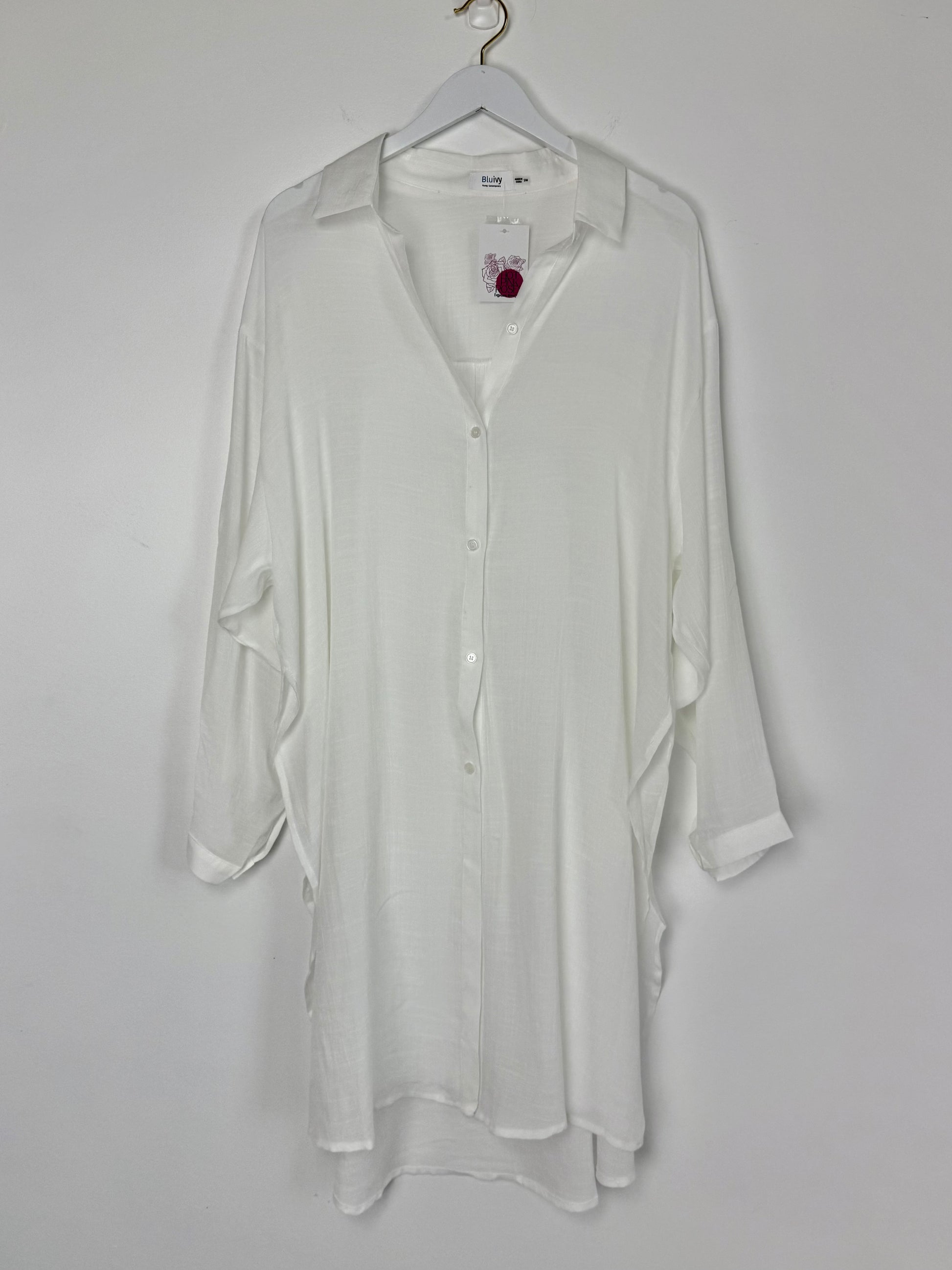 White shirt on a hanger against a white background