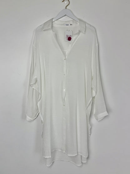 White shirt on a hanger against a white background