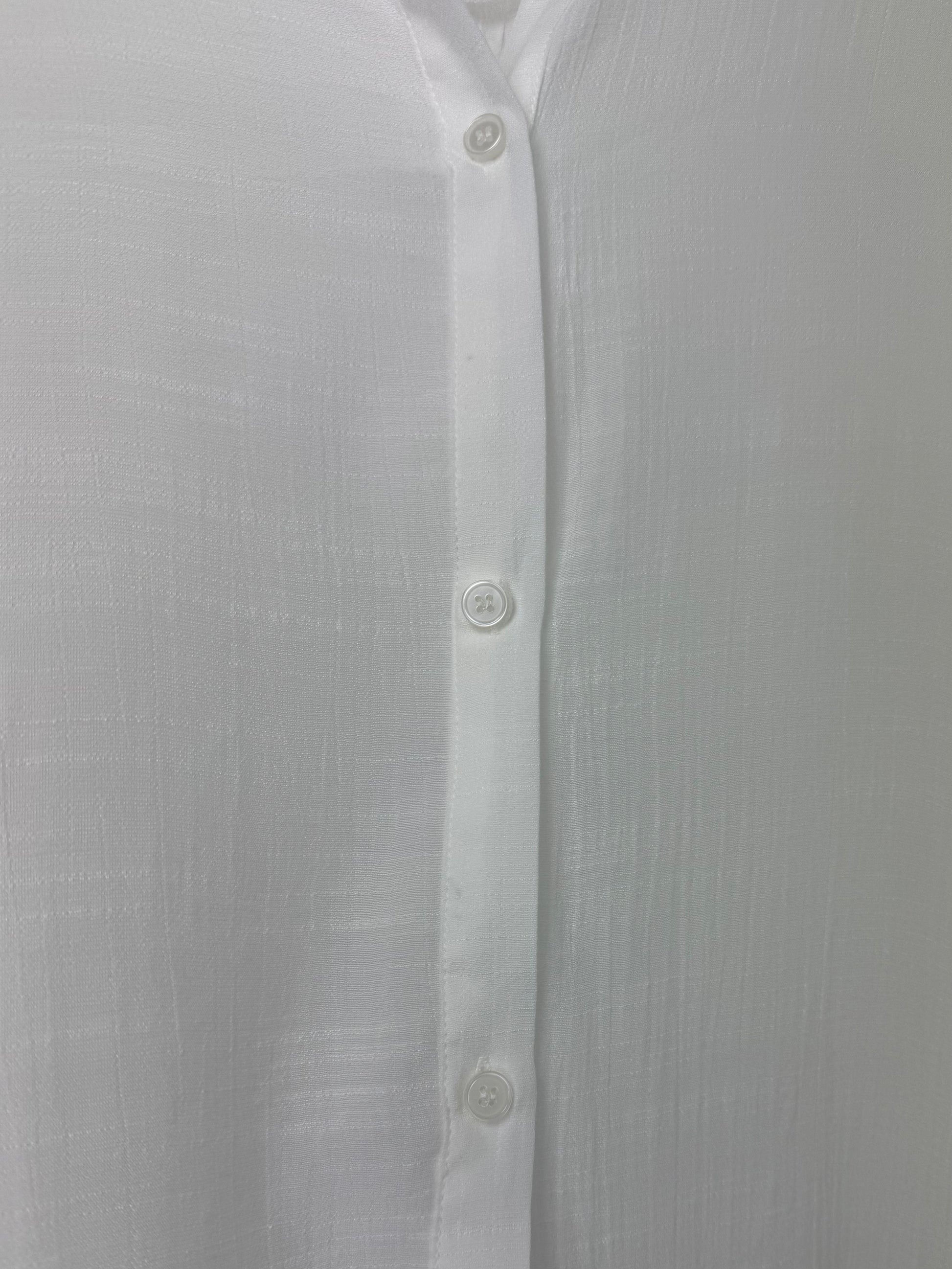 Close-up of a white button-up shirt with a plain background