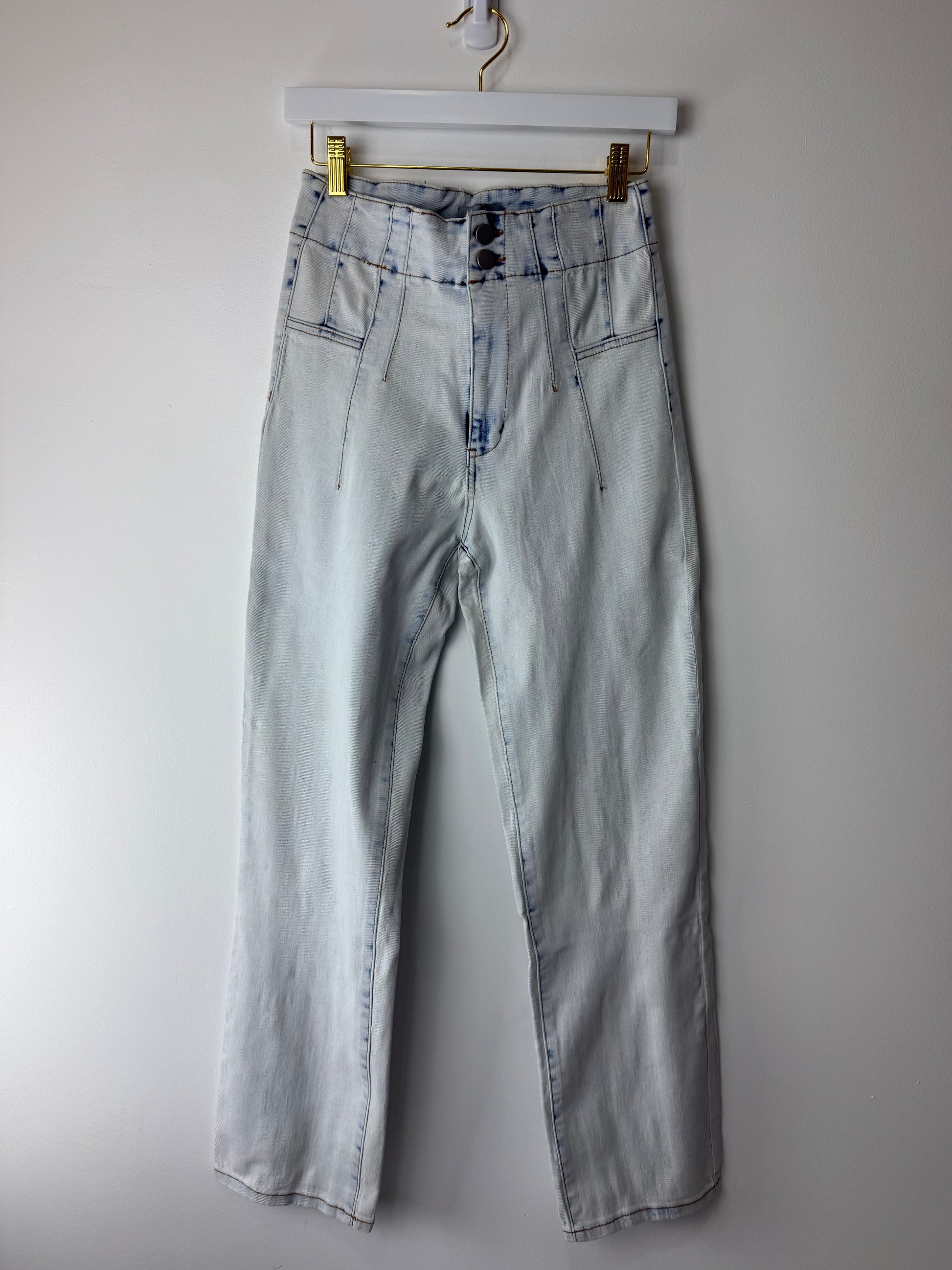 Light blue jeans on a hanger against a white background