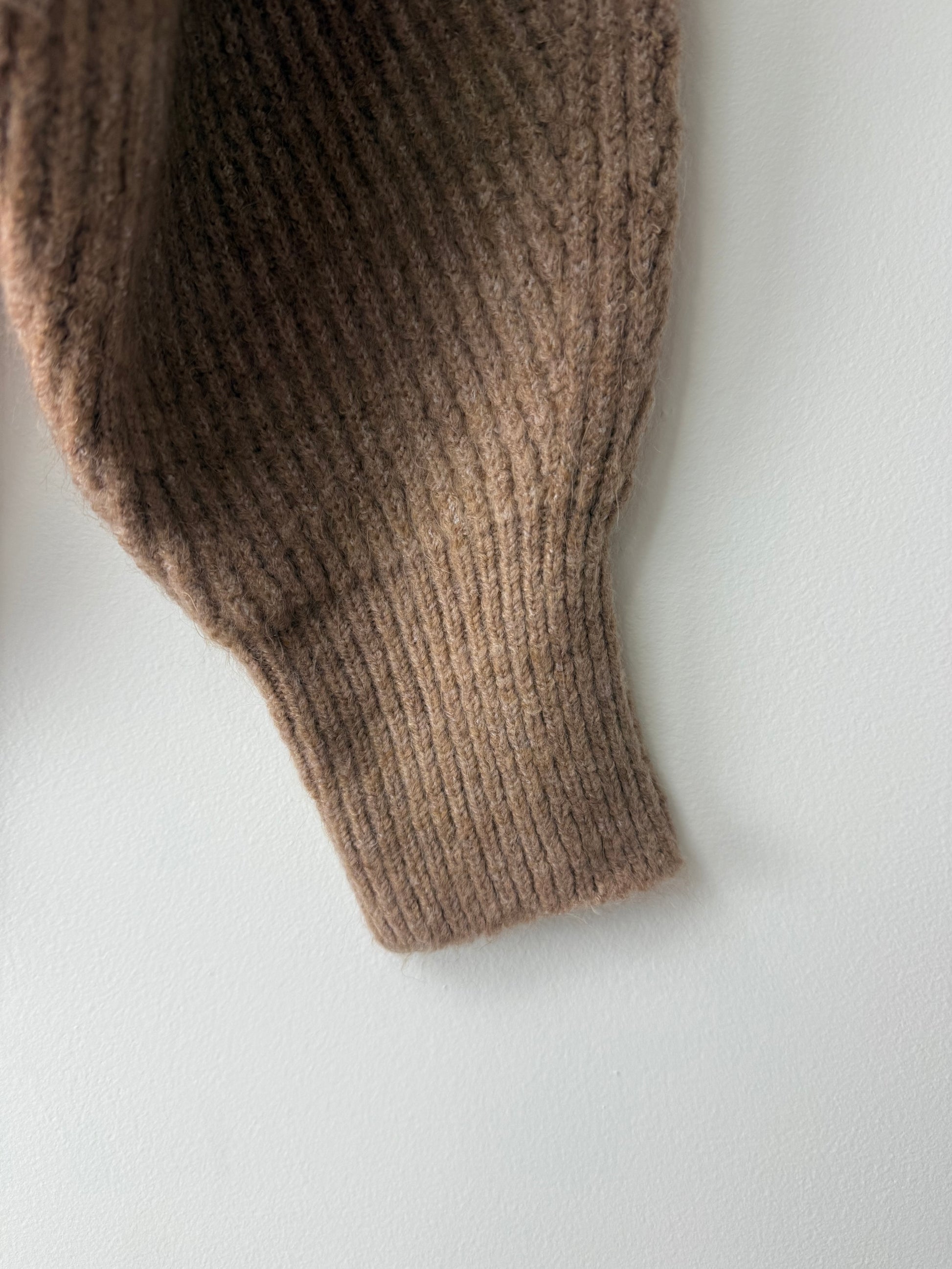 Brown knitted sweater sleeve on a white background