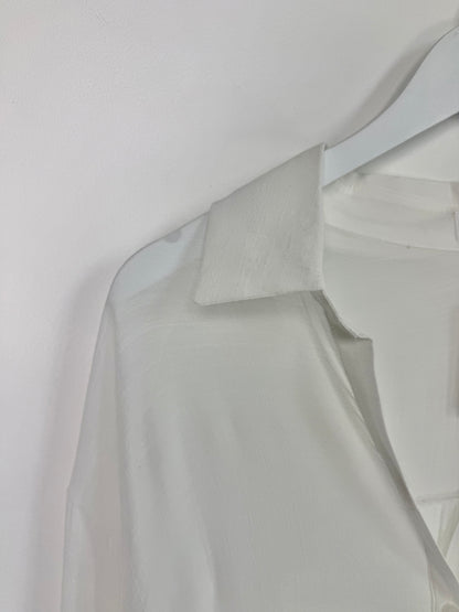 Light gray shirt on a hanger against a white background