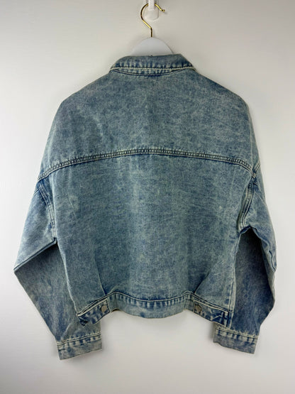 Blue denim jacket on a white hanger against a white background