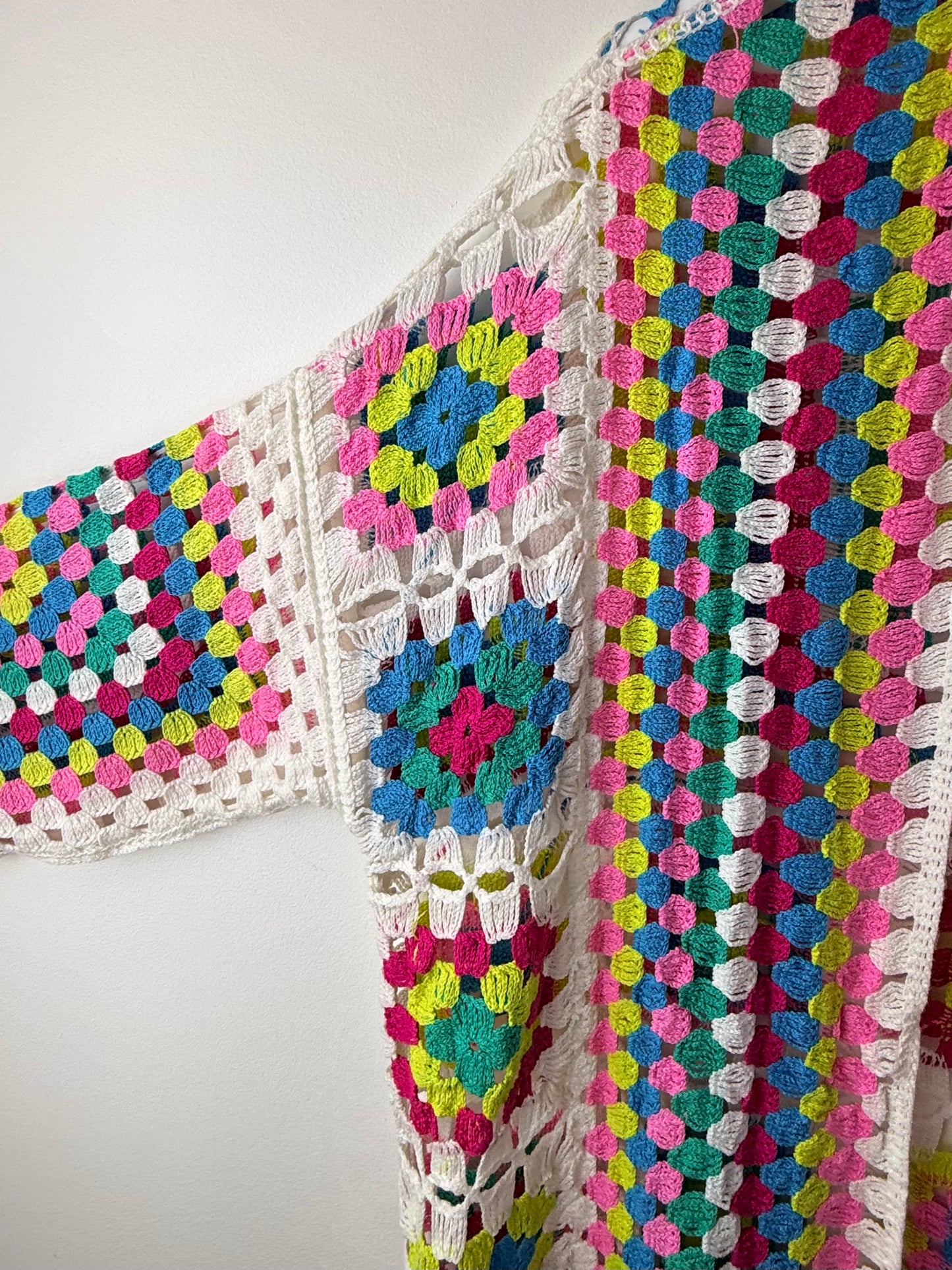 Colorful crocheted blanket with a geometric pattern on a white background