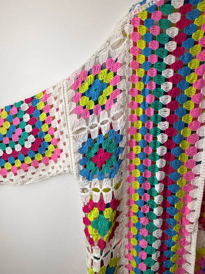Colorful crocheted blanket with a geometric pattern on a white background