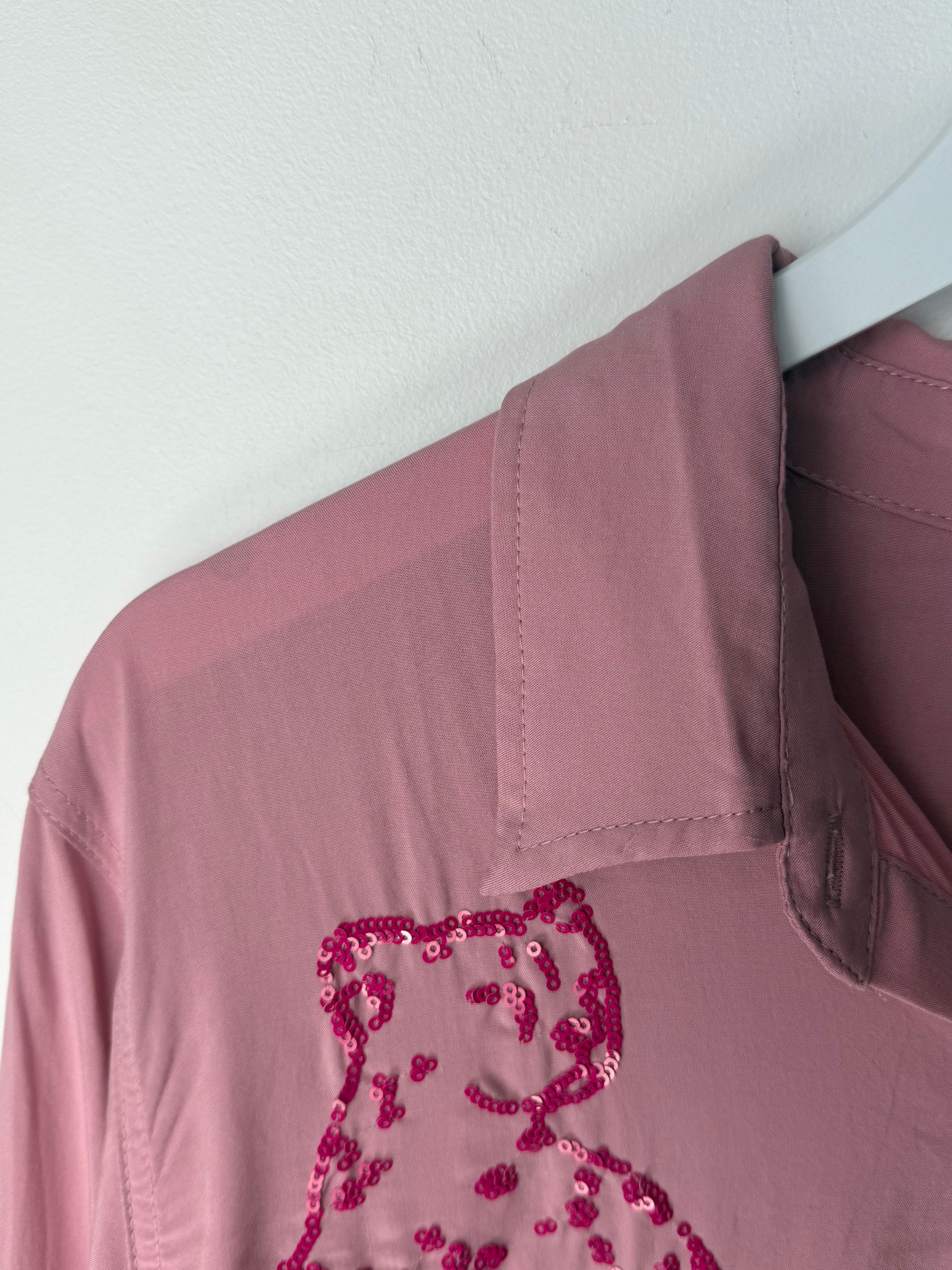 Pink button up with a sequined design on a white background