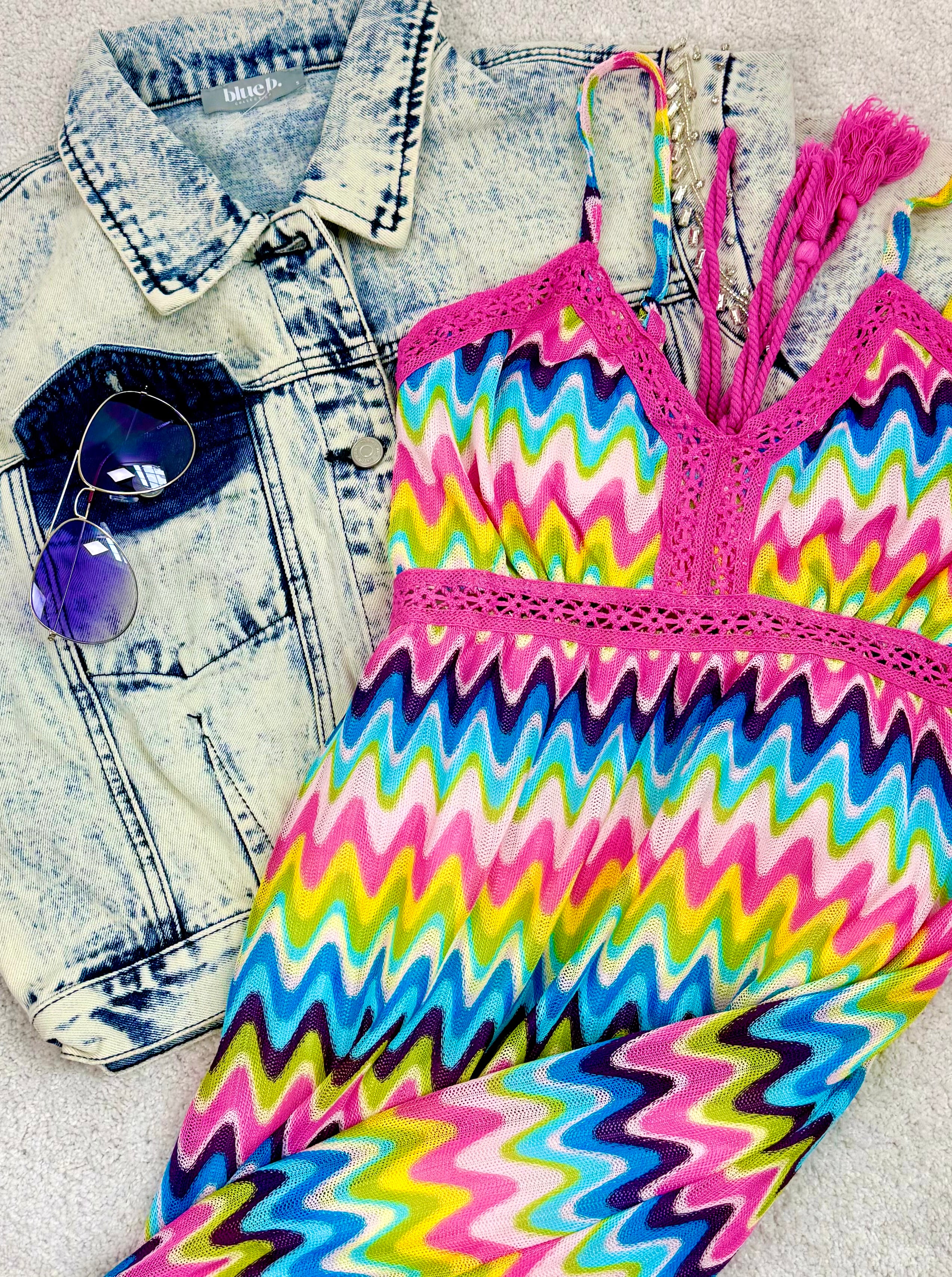 Colorful zigzag patterned top with pink straps on a denim jacket and sunglasses.