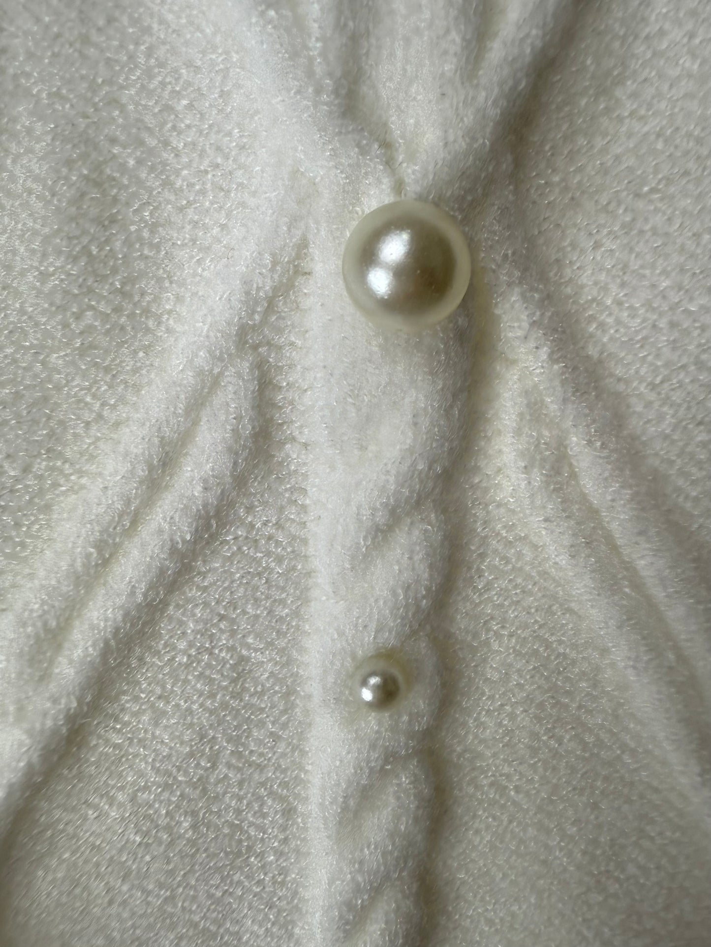 Close-up of a textured fabric with pearl buttons
