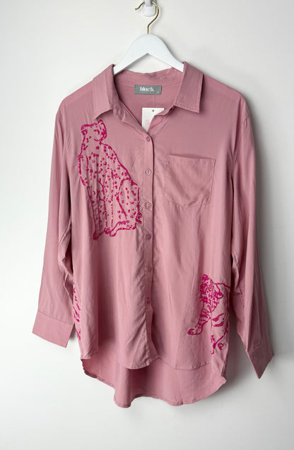 Pink button-up shirt with pink sequin graphics on a white background