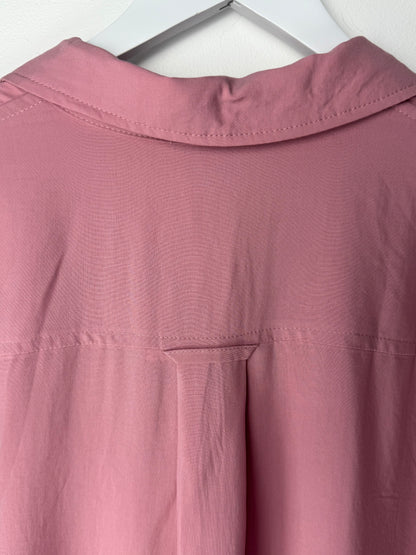 Close-up of a pink garment collar from back on a white background