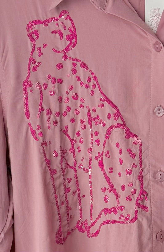 Pink shirt with a sequined panther design on a light pink background