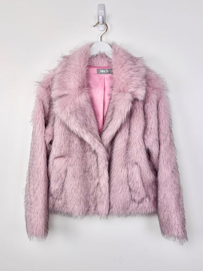 Pink faux fur jacket on a hanger against a white background