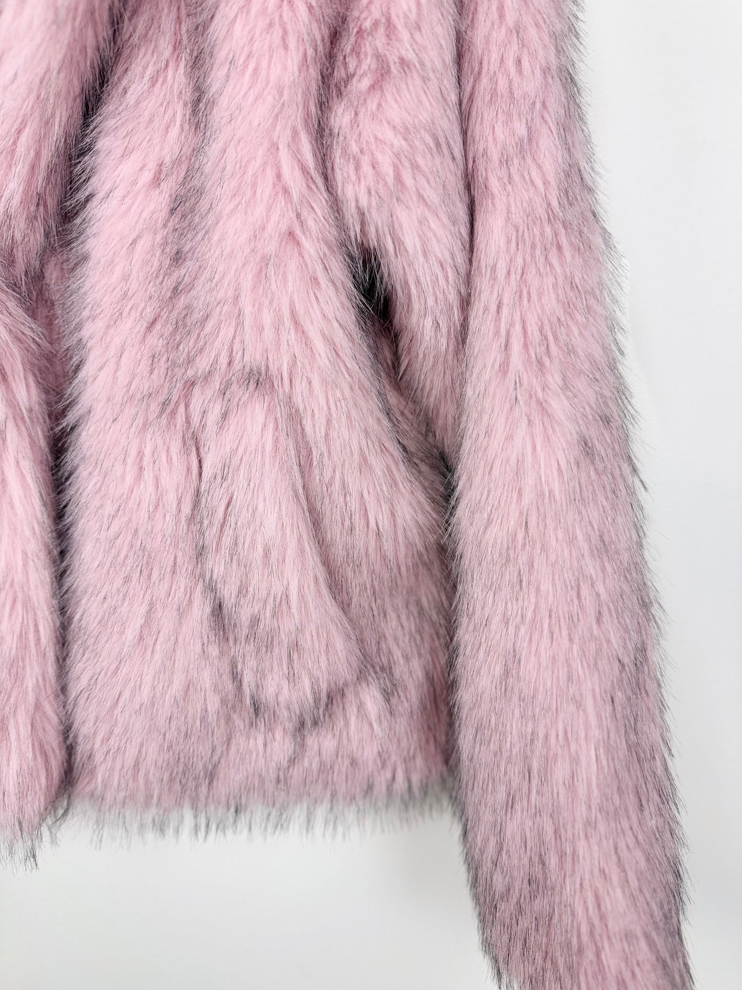 Close-up of a pink faux fur coat on a white background
