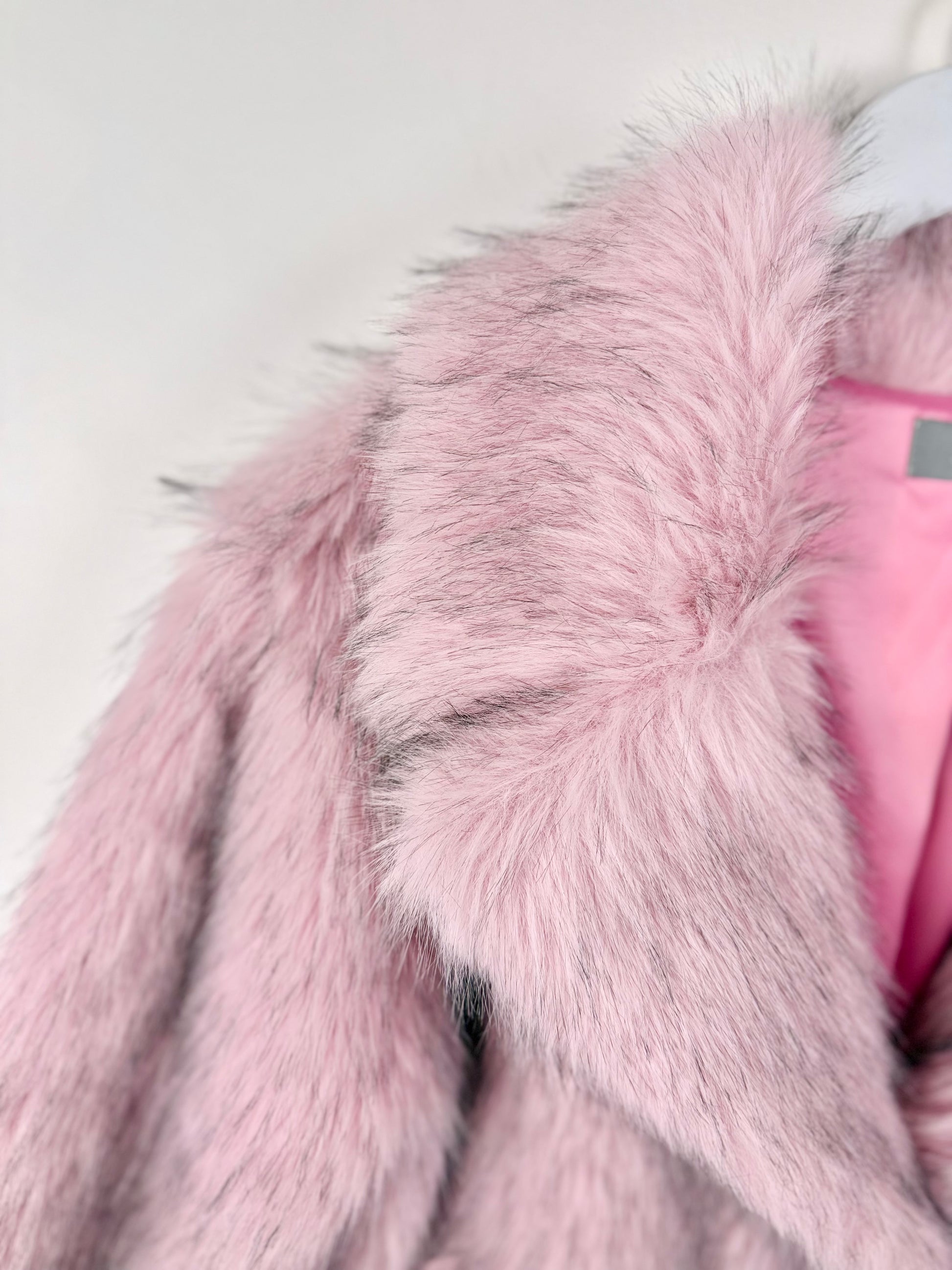Close-up of a pink fur coat with a white background