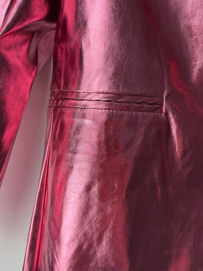 Close-up of a shiny metallic pink blazer with a plain background
