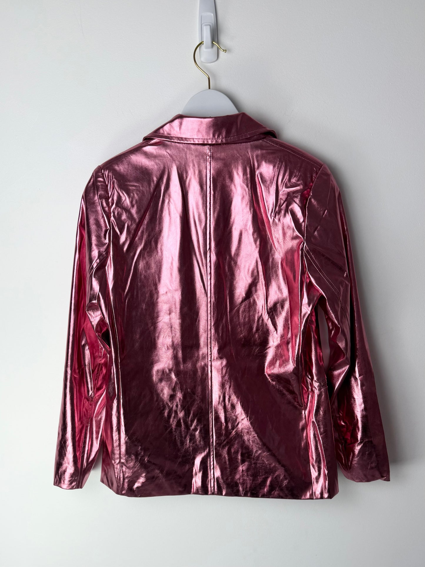 Shiny metallic pink leather jacket on a hanger against a white background