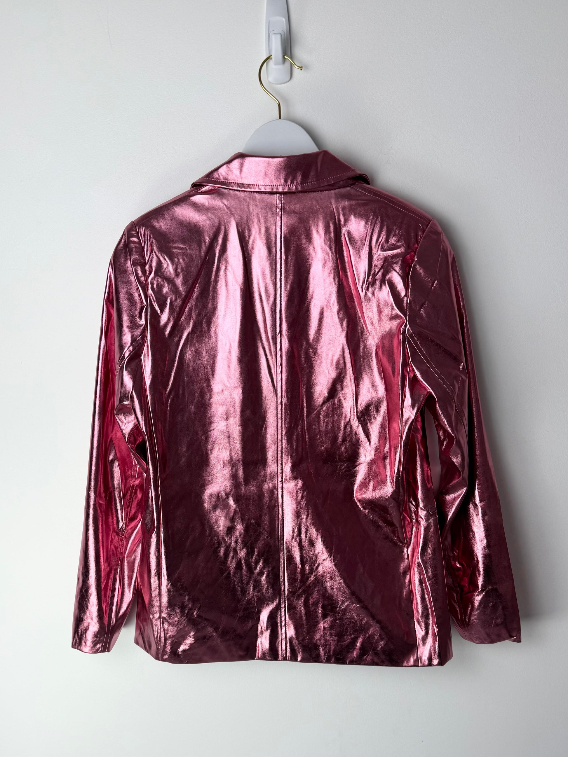 Shiny metallic pink leather jacket on a hanger against a white background