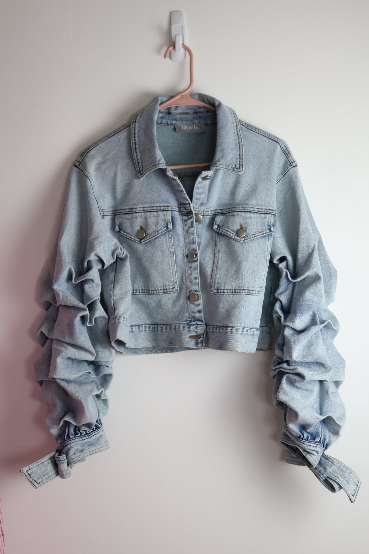 Ruched sleeve denim jacket hanging with white background