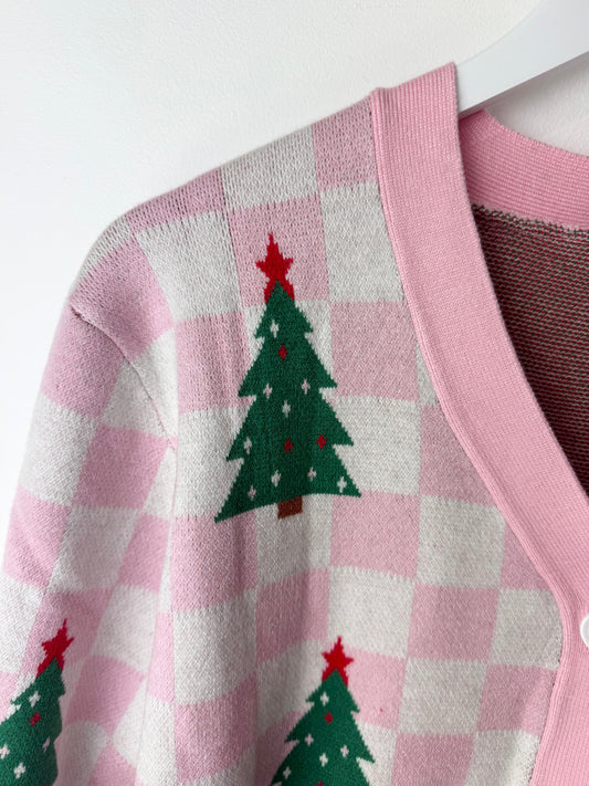 Pink checkered cardigan with green Christmas tree patterns on a white background