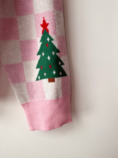 Checkered pink and white fabric with a green Christmas tree design on a light gray background