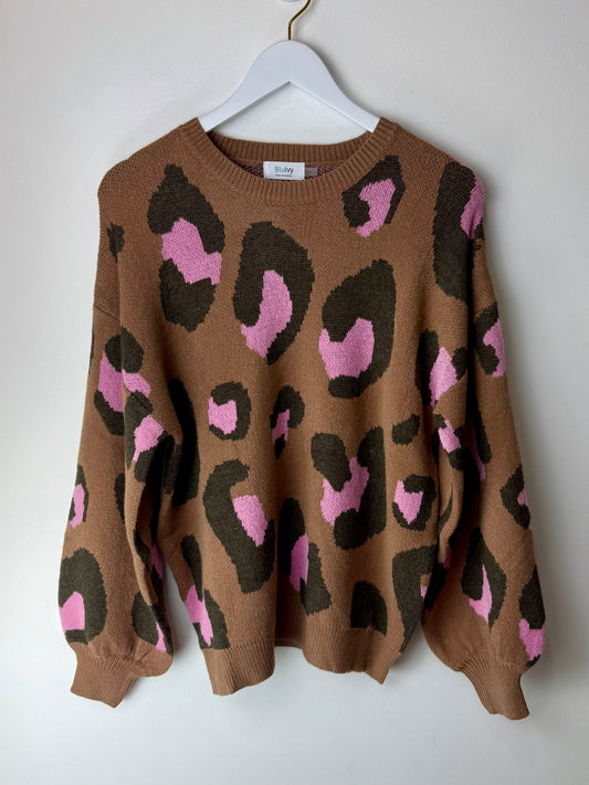 Brown sweater with pink and black leopard print on a white hanger against a white background