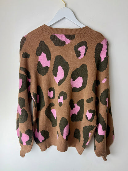 Brown sweater with pink and black leopard print on a white hanger against a white background