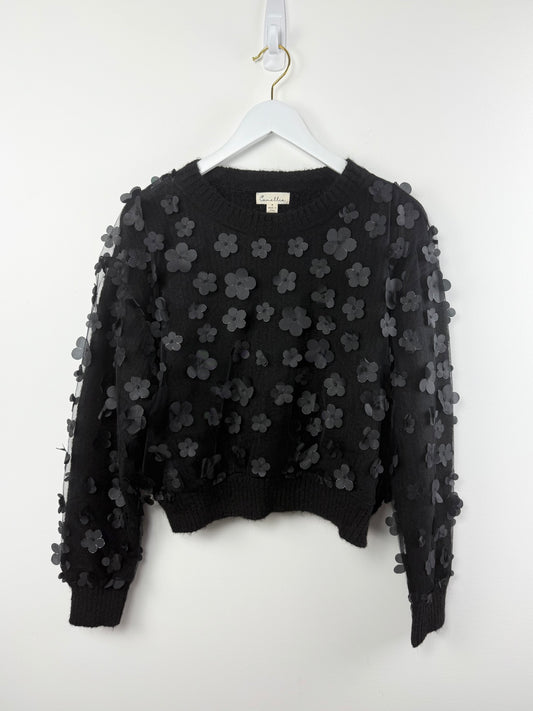 Black floral embroidered sweater on a white hanger against a white background
