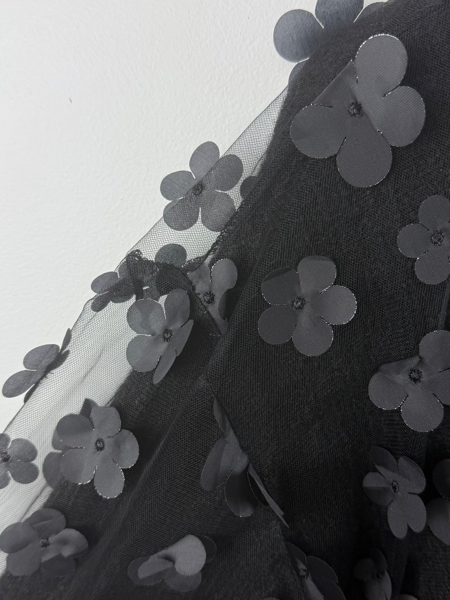 Black floral embroidery on a sheer fabric background