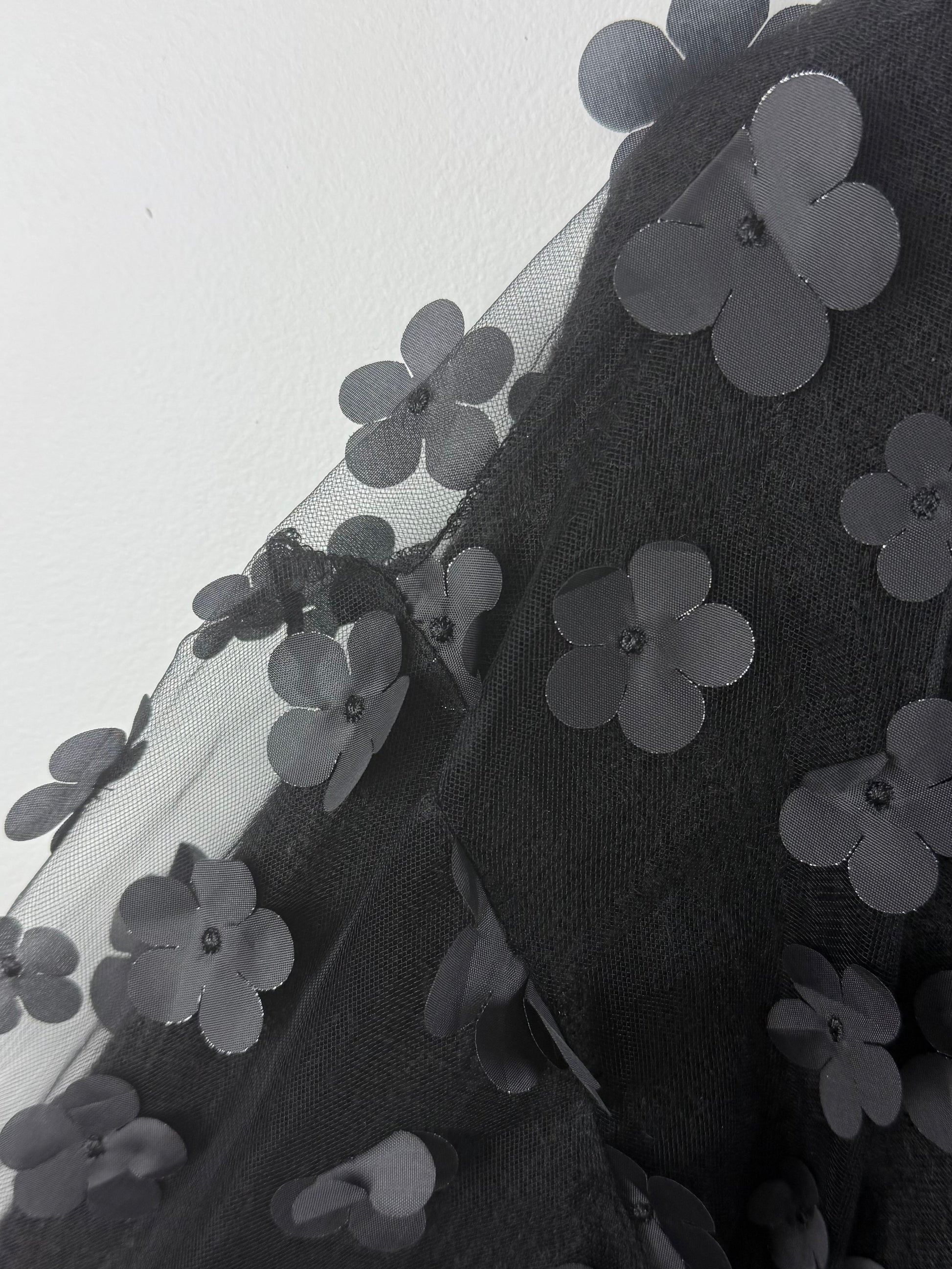 Black floral embroidery on a sheer fabric background