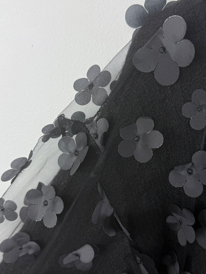 Black floral embroidery on a sheer fabric background