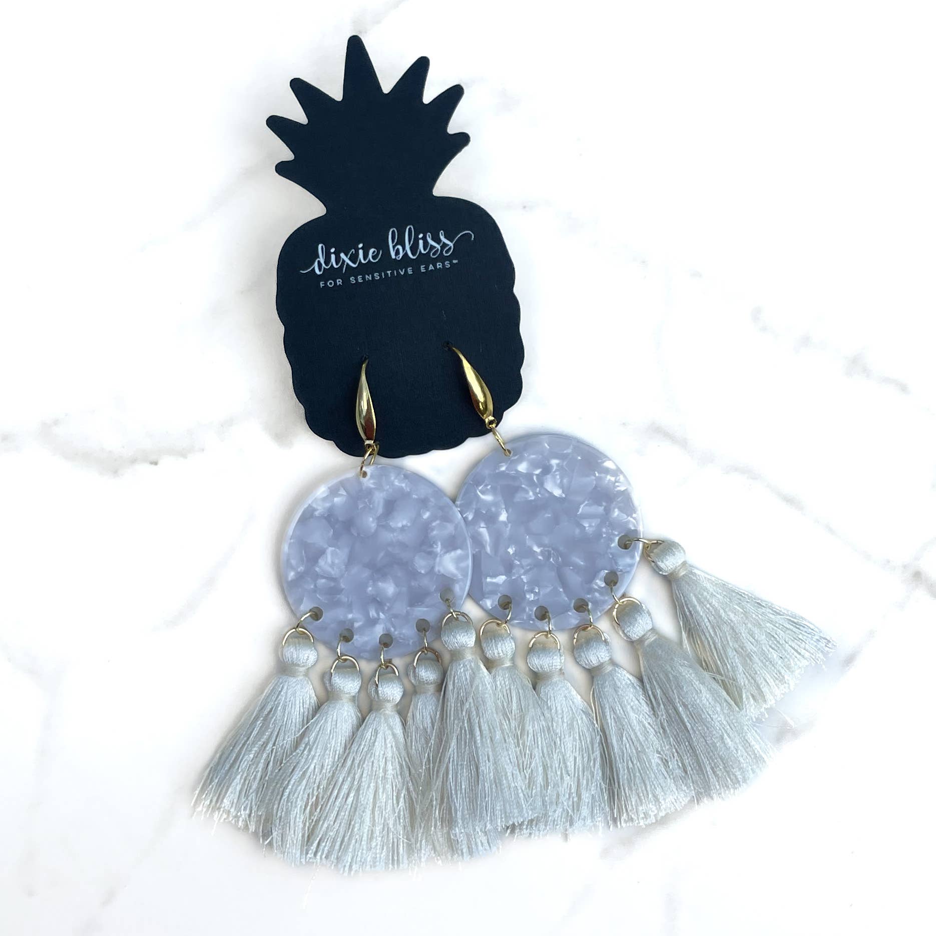 Dangle earrings with tassels on a Dixie Bliss branded card.