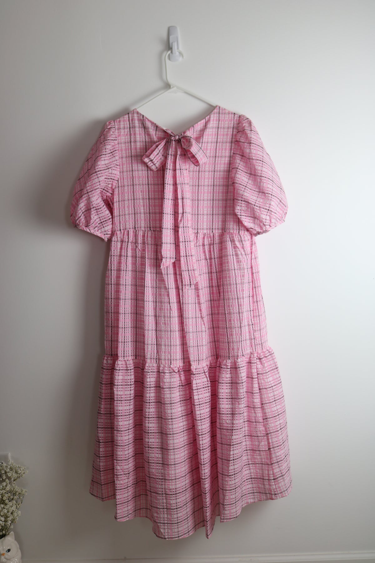 Pink dress hanging on white wall 