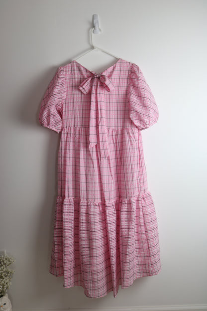 Pink dress hanging on white wall 